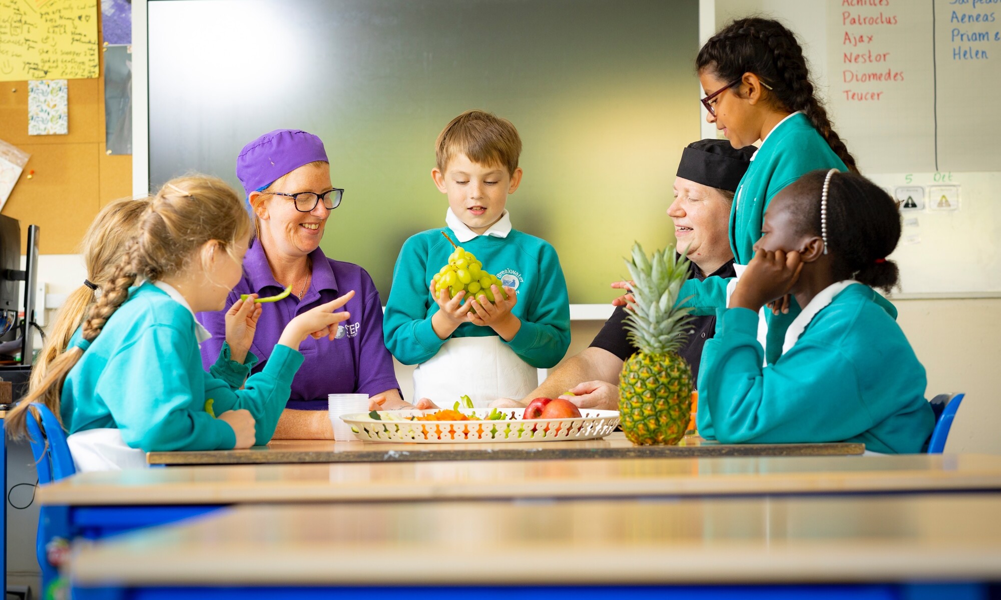 Breakwater Academy Image - Students and Teachers with Fruit